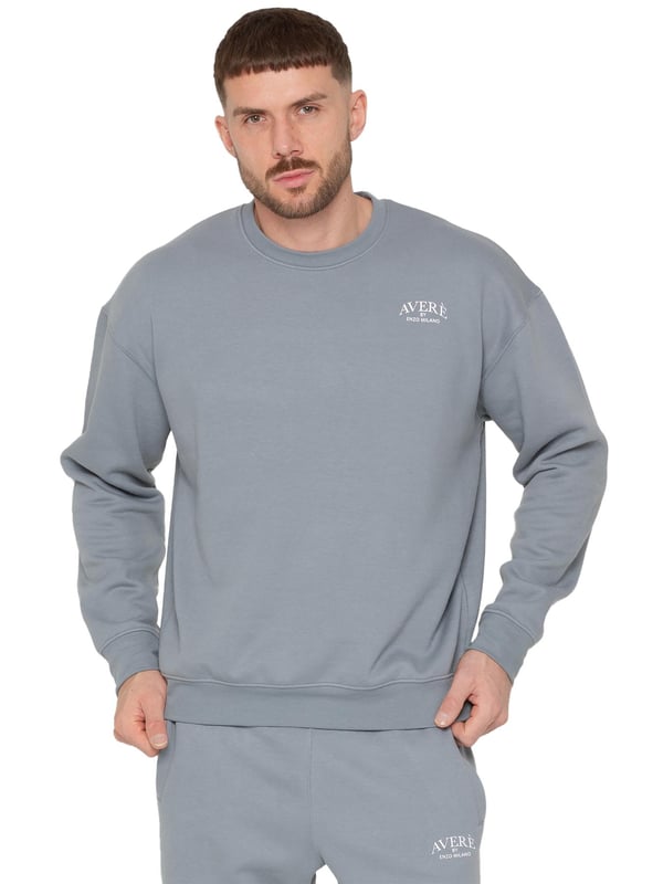El suéter oversized para hombre Averè de Enzo Milano presenta un ajuste relajado y casual, perfecto tanto para descansar como para el uso diario. El frente muestra un discreto logotipo de Averè en el pecho. El suéter tiene mangas largas y un cuello redondo acanalado con puños acanalados, lo que le da una silueta limpia y clásica. La tela suave y el forro de felpa garantizan comodidad, mientras que el corte de hombro caído mejora el aspecto oversized. La parte trasera permanece lisa, manteniendo un estilo simple y elegante. Ideal para combinar con pantalones de chándal o jeans para un atuendo relajado.