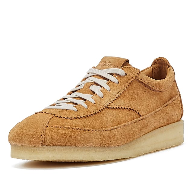 Introducing a premium mid-tan suede upper shoe with a sleek trainer silhouette, featuring tonal top-stitch details, complemented by a comfortable crepe sole. Finished with two Clarks Originals fobs.