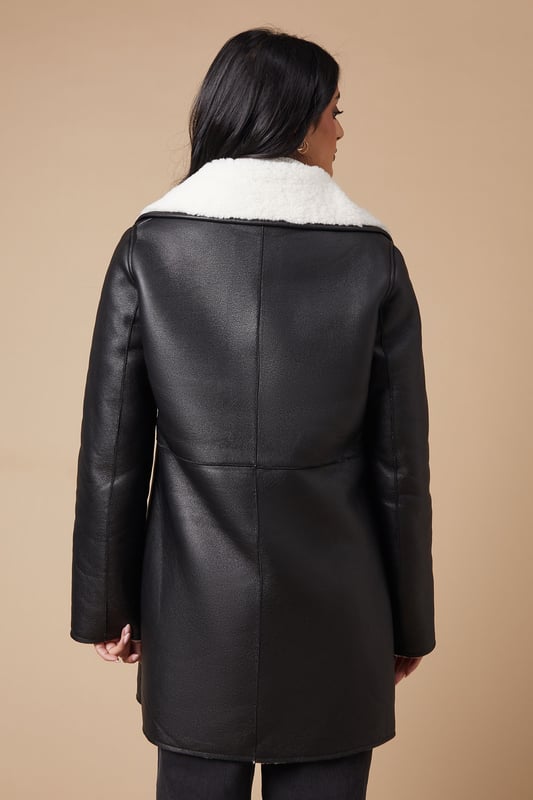 Double-breasted design for a classic, sophisticated look
        Contrasting shearling collar and lining for added warmth and style
        Oversized lapels create a dramatic, fashion-forward silhouette
        Multiple buttons for adjustable closure and fit
        Mid-thigh length offers versatile coverage for various outfits
    
    This double-breasted shearling coat from Oasis is the perfect blend of style and cosiness for the cooler months. The contrasting shearling collar and lining not only provide extra warmth but also add a luxurious touch to the overall design. Style this coat with a crisp white turtleneck and dark trousers for a chic daytime look, or throw it over a floral dress for a pretty evening ensemble. The versatile mid-thigh length makes it suitable for various occasions, from casual weekend outings to family gatherings. For a complete look, pair with ankle boots and a cross-body bag. This coat is an investment piece that will keep you looking stylish and feeling snug throughout the autumn and winter seasons.