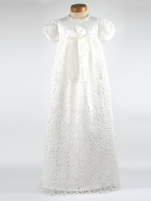 We have reintroduced one of our popular gowns - Ruby. 
  
A stunning Christening robe made with Guipure Lace. A full length dress with a satin bodice, lace sleeves and a beautiful front detail of an organza flower on stunning ribbon tails.  Your child will look very special on the day! 
  
We line our dresses and robes in 100% lightweight Cotton lawn fabric which is cool and better against babies body, especially if they have sensitive skin 
  
The gown arrives to you on a padded Satin hanger and protected by one of our Heritage keepsake garment bags. 
  
Outer - 100% Polyester Mock Silk - Ivory 
Lining - 100% Cotton 
Dry Clean or Hand Wash