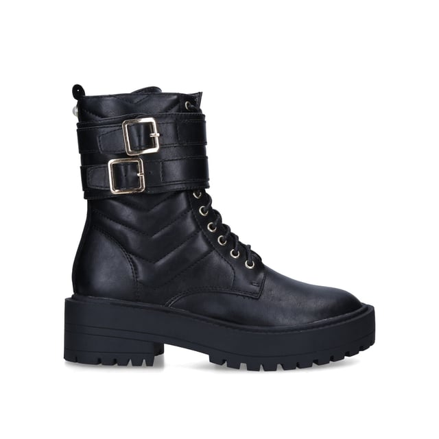The Indiana ankle boot features a black upper with matelassé quilting and two gold toned buckles. There is a black velvet panel and faux pearl stud at the back of the ankle.