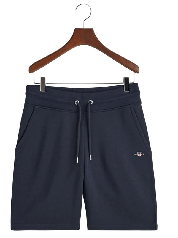 Gant introduces a mens t-shirt and shorts set with a small-scale embroidered shield graphic on the chest. Made of soft cotton and featuring a ribbed neckline, this tee showcases the iconic GANT logo. Crafted for everyday wear, the regular-fit tee is both comfortable and sustainable with Better Cotton. The included sweat shorts, also made of soft cotton blend, feature a ribbed waistband, three pockets, and a drawstring waist. The shorts are adorned with a small-scale embroidered shield graphic.