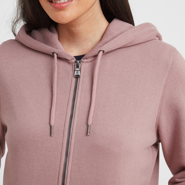 A wardrobe staple, our Mia zip through hoody comes in a supersoft brushed back fleece finish, so soft and cosy that you won't want to take it off. A layer you can easily throw on for a blustery walk across the moors, popping to the gym or meeting up with friends, giving you much needed insulation on chilly days. This classic hoody has a premium feel and keeps its shape for years to come thanks to generous ribbing to the cuffs and hem and the opening of the snug, split kangaroo pocket. The double fabric drawcord hood is warm and cosy and keeps the wind out of your ears. Mia comes in colours inspired by wild moorland heather, celebrating our proud Yorkshire heritage, and is finished with a small branded woven Truth Over Glory label on the pocket.