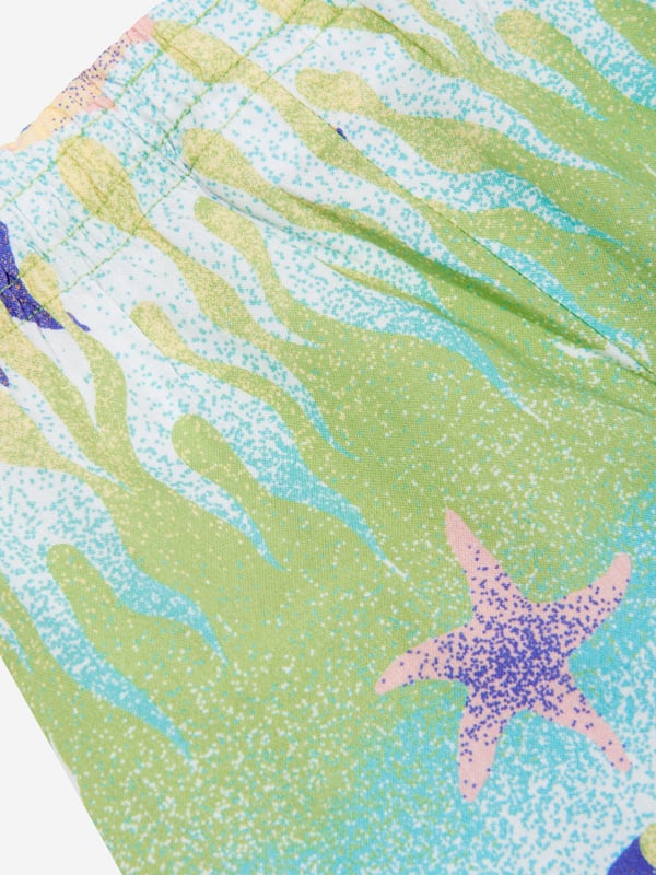 Introducing the high-end Baby Boys Under The Sea Shorts in Green by Molo. The perfect addition to spruce up your baby boy's holiday wardrobe, this piece asserts style and comfort hand in hand. Here's what sets it apart:  Playful Print: This trendy sea-themed print adds zest and vibrancy to these shorts, making it a striking ensemble.  Supreme Comfort: Crafted from top-tier materials, these shorts offer unparalleled comfort, allowing your little one to frolic around with ease. Wardrobe Makeover: Step up your baby boy's fashion game with these Under The Sea Shorts in Green by Molo. Secure your pair today and let your little man make a stylish splash!