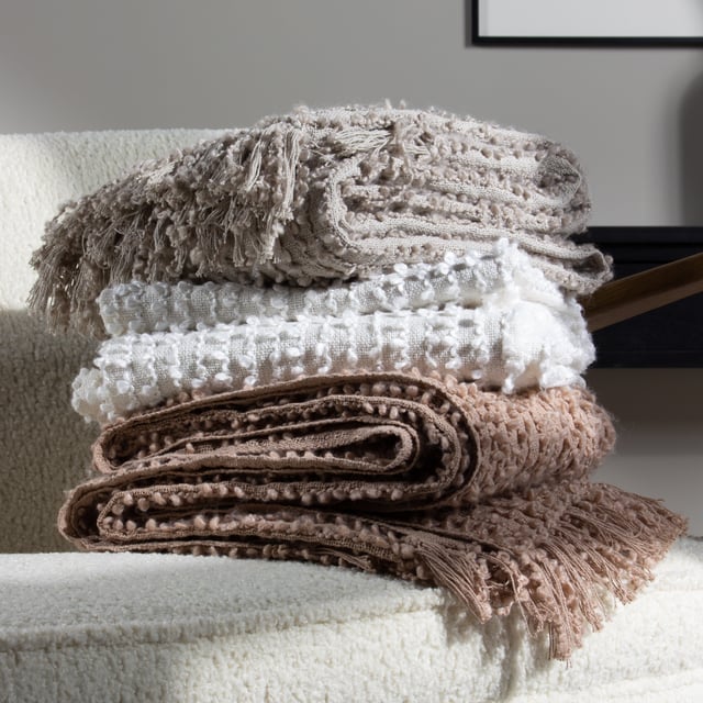 Add instant style and texture to any space with the Arvo throw. This woven design is adorned with elegant strands of vertical boucle yarn, which slide gracefully down the piece, until they meet the textural fringing at both ends. It comes in a range of muted, chic tones, which are inspired by modern neutrals and fashion fabrics. A simple, but polished throw to drape on your sofa or bed to add instant style and texture to your home.