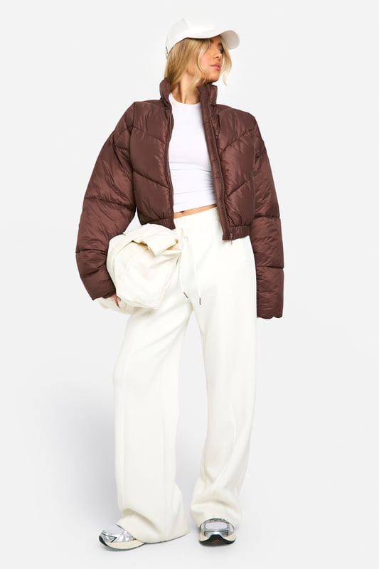 Quilted puffer jacket with funnel neck design
        Cropped length for a trendy silhouette
        Full-length zip closure for easy wear
        Chevron quilting pattern adds visual interest
        Ribbed cuffs for a snug fit and warmth retention
    
    Embrace the chilly weather in style with this eye-catching quilted puffer jacket. The funnel neck design not only adds a fashionable touch but also provides extra warmth on blustery days. Its cropped length makes it perfect for pairing with high-waisted trousers or skirts, creating a balanced and modern look. For a casual day out, team it with wide-leg trousers and trainers, as shown in the images. Add a baseball cap for an extra sporty vibe. This versatile piece is ideal for various casual occasions, from weekend brunches to shopping trips with friends. The chevron quilting pattern adds a subtle yet stylish detail, ensuring you stand out in the crowd. Whether you're heading to a family gathering or a casual meet-up, this jacket will keep you cosy without compromising on style.