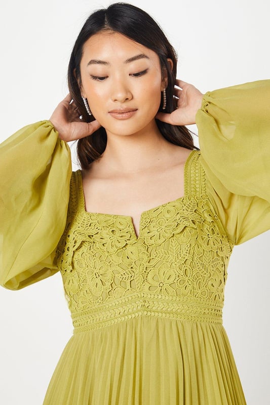 Exquisite lace bodice with intricate floral detailing
        Elegant square neckline for a sophisticated look
        Voluminous bishop sleeves add drama and flair
        Pleated chiffon skirt creates graceful movement
        Midi length perfect for formal occasions
    
    This stunning Coast dress combines timeless elegance with contemporary flair, making it an ideal choice for weddings, races, or any sophisticated soire. The lace bodice, adorned with delicate floral patterns, creates a captivating focal point, while the square neckline frames the dcolletage beautifully. The billowing bishop sleeves add a touch of romance and drama to the silhouette. The pleated chiffon skirt flows gracefully from the waist, offering both comfort and style as you move. To complete your ensemble, pair this dress with strappy metallic heels and delicate drop earrings. For a polished daytime look, layer with a tailored blazer and accessorise with a fascinator for the races. This versatile piece effortlessly transitions from day to evening events, ensuring you'll be the epitome of sophistication at any occasion.