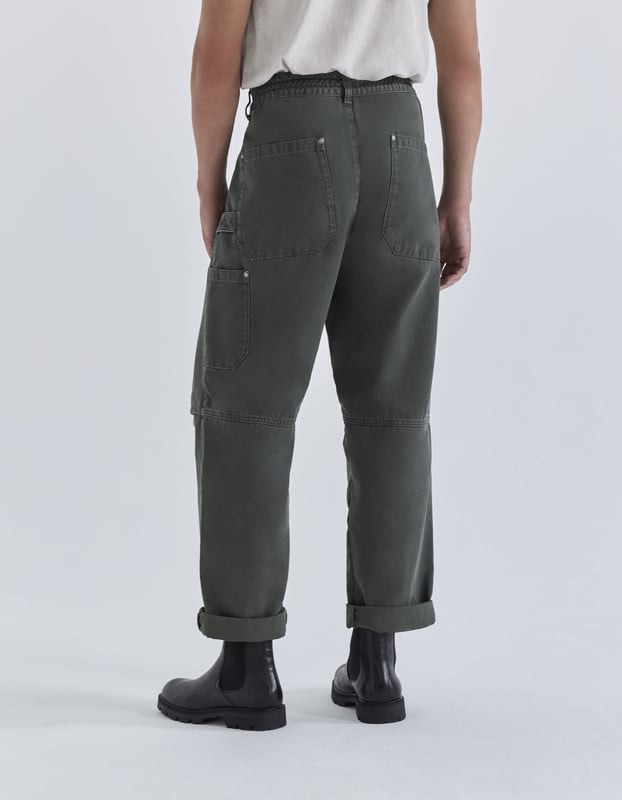 This cropped trousers has an elastic waist, zip and buttons fastening and pockets.