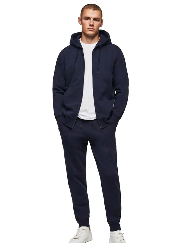 Der Kruze Mens Zip Up Hoodie ist ein hochwertiges Trainingsanzug-Set, das von Enzo entworfen wurde. Dieser Kapuzenpullover mit normaler Passform und Reißverschluss verfügt über Kängurutaschen und Bündchen an den Ärmeln, gepaart mit passenden Jogginghosen. Der elastische Bund und der verstellbare Kordelzug sind für ultimativen Komfort mit einem gebürsteten Innenfleece versehen. 52 % Baumwolle, 48 % Polyester. Erhältlich in den Farben Schwarz, Grau und Marineblau.