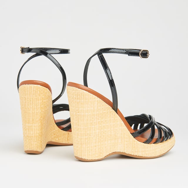 LK Bennett SOLANGE Sandals, Black With a hint of Seventies' playfulness, our Solange wedges balance height and comfort. Crafted in Italy from black patent leather, they have a crossover multi-strap design, a delicate ankle strap and a beige raffia 110mm wedge sole. Perfect with summer's cool cotton and linen skirts and dresses, they're also great with wide leg trousers.
