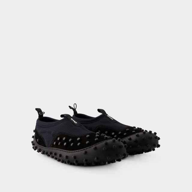 Dies sind die Millechiodi Sneakers von Sunnei, wo avantgardistisches Design auf zeitgemäßen Komfort trifft. Diese Sneakers verbinden mühelos einen avantgardistischen Stil mit moderner Praktikabilität, wobei das einzigartige Detail mit mehreren Schnürsenkeln für einen Hauch von Individualität sorgt. Für einen originellen Stil kombinieren Sie sie mit einer weiten Hose und einem übergroßen Grafik-T-Shirt. Diese unerwartete Kombination schafft einen topmodischen Look, der sich perfekt für einen Besuch auf statement bei der Eröffnung einer Kunstgalerie oder auf einer angesagten Party eignet. Sunnei Die Millechiodi Sneakers von brand's verdeutlichen das Engagement der Marke für Qualität und Mode, indem sie Ihnen eine unverwechselbare und vielseitige Wahl bieten, die mühelos modernen Charme mit Komfort und Eleganz vereint. Gehen Sie selbstbewusst und mit Ihrem persönlichen Sinn für Stil in diesen ikonischen Sneakers aus dem Haus und unterstreichen Sie Ihr einzigartiges Modebewusstsein. Farben: Schwarz - Black. Hauptmaterial: polyamide. Material Sohle: Gummi. Verschluss: einfach reinschlüpfen. Form der Kappe: mandel-förmig. Fällt normal aus - Sizing: Width: 10. Height: 2. Length: 26.