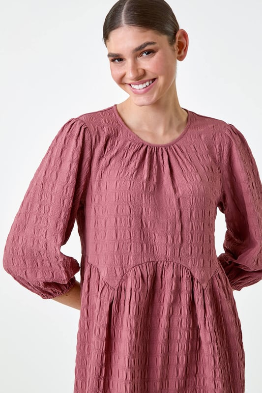 Bubble Textured A-Line Stretch Dress from Roman. Add pretty textures to your everyday collection this season, with this easy-to-wear A-line dress. Crafted from a stretch jersey fabric, this piece features a modest round neckline and 3/4 length sleeves, finished with elasticated cuffs. An empire waistline ensures a flattering and comfortable fit, while the all-over texture provides interest throughout. Pair with sandals and a denim jacket for a laid-back look, or add wedges and a sun hat for a day at the beach club!