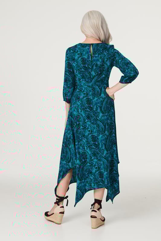 Add an chic asymmetric style to your dress collection with this chic paisley midi. It has a round neck, 3/4 sleeves, a keyhole back, a cinched waist and an elegant midi length skirt with a hanky hem detail. Pair with neutral heels for a daytime style you can wear for anything from lunch with the girls to a day at the races.
