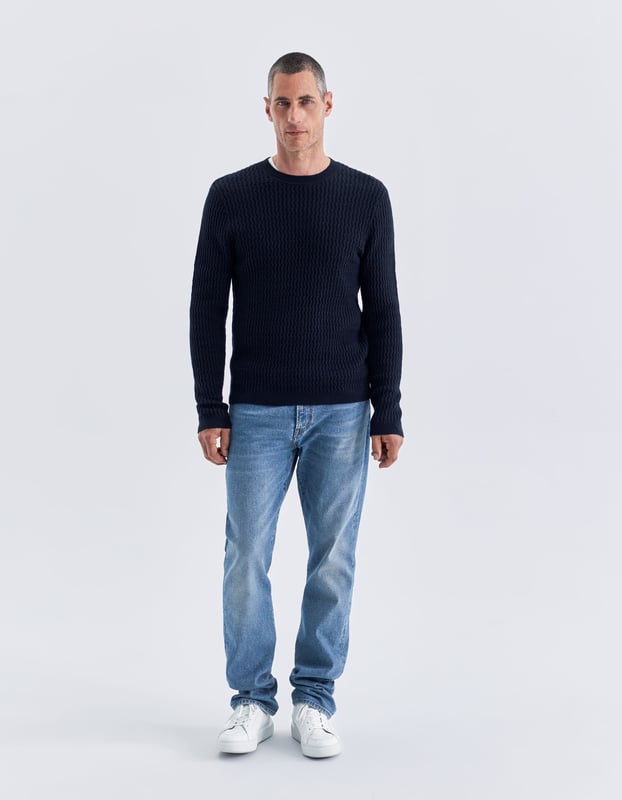 This navy jumper has round neck and long sleeves. It is relieved knit with fine twists.