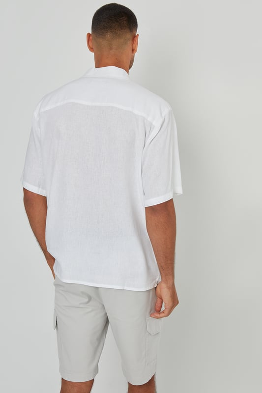 This lightweight shirt from Threadbare will have you ready for the summer months. Crafted from a cool linen blend fabric, this regular fit shirt features a revere collar with single needle stitching and a button-through fastening. The short sleeves and side split vents offer comfort and breathability. Complete with a back yoke seam for added detail, this shirt is perfect for casual outings or beachside gatherings. Pair it with tailored shorts or lightweight trousers for a relaxed look.