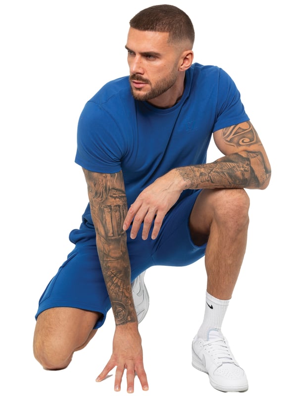Enzo T-shirt trainingspak voor heren met korte broek. T-shirt met ronde hals en korte mouwen. Zachte, comfortabele top met normale pasvorm. Voorzien van EZ-logo op de borst gedrukt. In combinatie met Enzo Cargo-shorts. Elastische tailleband met verstelbaar trekkoord. Voorzien van 2 zijzakken en 2 cargozakken.