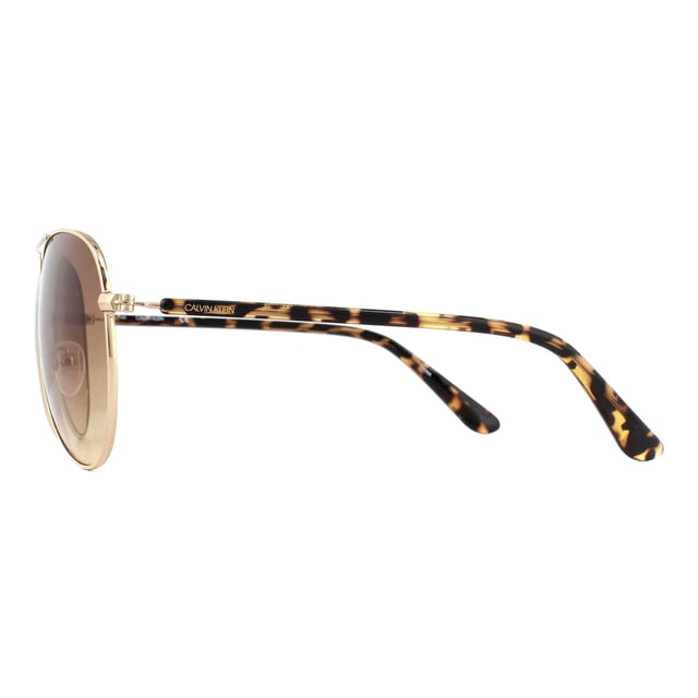 Calvin Klein Sunglasses CK19314S 717 Gold Tortoise Brown Gradient are a typical aviator style with large teardrop shaped lenses. A metal frame front features adjustable nose pads, and plastic temples showcase the Calvin Klein logo.