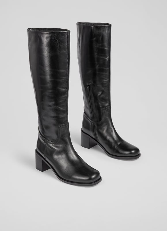 Imagine striding through cobblestone streets with an air of effortless elegance. The Claude knee boots, crafted from black Italian calf leather, feature a stylish block heel and a sophisticated rounded square toe. Perfectly versatile, pair them with tailored trousers for a smart look or with a flowing midi skirt for a casual charm.