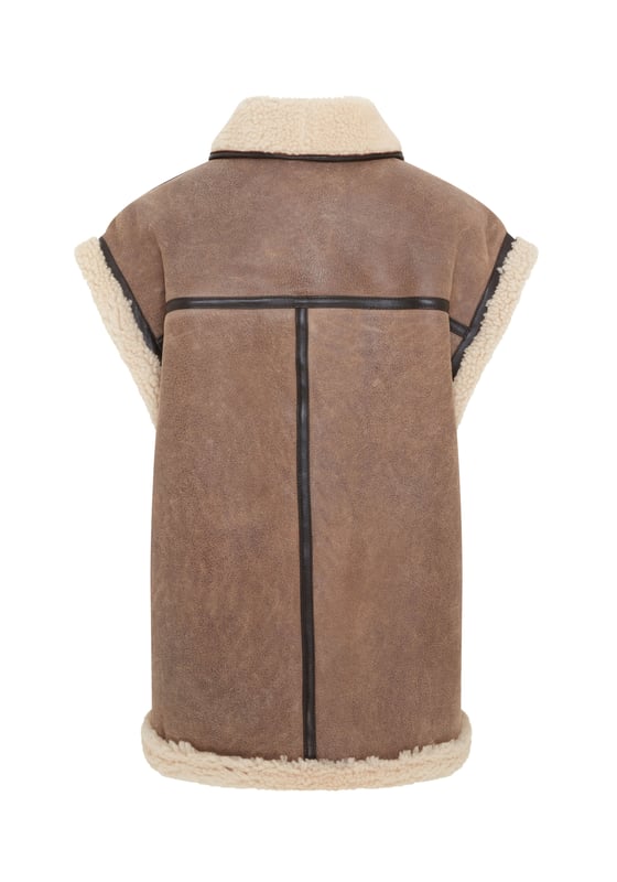 Añade una elegancia atemporal a tu vestuario de invierno con este chaleco de piel de oveja de borrego para mujer, una combinación armoniosa de sofisticación y comodidad. Con un lujoso color marrón tostado, forro de piel de oveja afelpada y detalles de ribetes de cuero. Perfecto para usar en capas, combina una calidez excepcional con un encanto atemporal. • Piel de oveja de borrego de doble cara de primera calidad • Forro de piel de oveja afelpada para una comodidad superior • Cierre con botones para un aspecto clásico • Detalles de ribetes de cuero para una mayor elegancia • 2 bolsillos laterales para mayor comodidad • Cuello versátil, se puede llevar hacia arriba o hacia abajo para darle estilo y calidez
