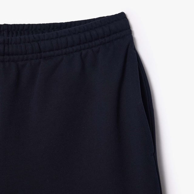Own the french fashion sport The Joggers tracksuits : Comfort shape Regular fit  regular ease on body  hip and leg Shorts in our classic French Terry Climbing style drawcords 5cm puffed badge with silicone crocodile sewn at bottom Lacoste wording in flock print.