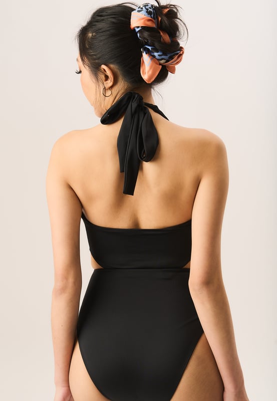 Con nuestro nuevo traje de baño halter con abertura retorcida en azul cobalto, puedes darle a tu conjunto de playa un toque elegante. Con un escote en V pronunciado con un frente retorcido y cortes laterales atrevidos, puedes combinarlo con joyas doradas y gafas de sol para una apariencia hermosa.