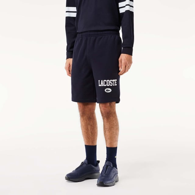 Own the french fashion sport The Joggers tracksuits : Comfort shape Regular fit  regular ease on body  hip and leg Shorts in our classic French Terry Climbing style drawcords 5cm puffed badge with silicone crocodile sewn at bottom Lacoste wording in flock print.