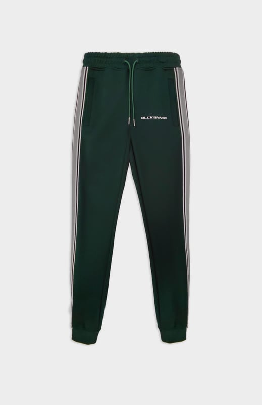 100% Polyester Elastischer Hosenbund mit Kordelzug Reißverschlusstaschen BLCK BNNS am rechten Bein Sportliches Streifenband an den Seiten Kombinierbar mit MIAMI TAPED TRACKTOP 
