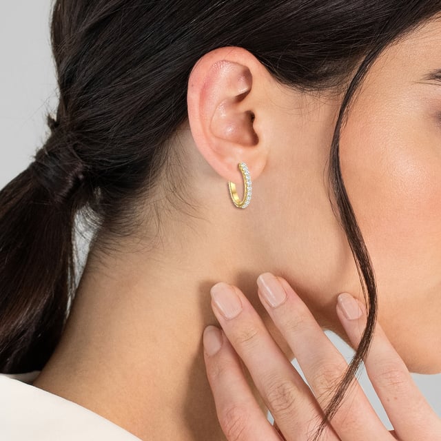 Glamorous earrings are a must -have for all jewelry lovers - like these creoles of the Trilani label. The design convinces with its classic-time circular form. Made of 925 sterling silver and refined with yellow gold, the earrings are perfect for all fans of the warm shimmering precious metal nuance. Coating is the lush trim with zirconia crystals, the diamond cut of which ensures an enchanting sparkle on your earlobes. These creoles are a combination talent that harmonizes the office outfit as well as a casual look in leisure. A practical folding cap offers optimal wearing comfort and simplifies it.