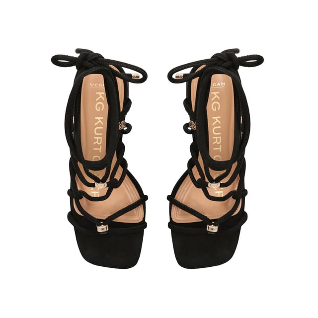 The KG Kurt Geiger Raya heel features a black microsuede upper with gold and KG Kurt Geiger stud hoops connecting the straps. The heel is a classic high block style. Heel height: 70mm.