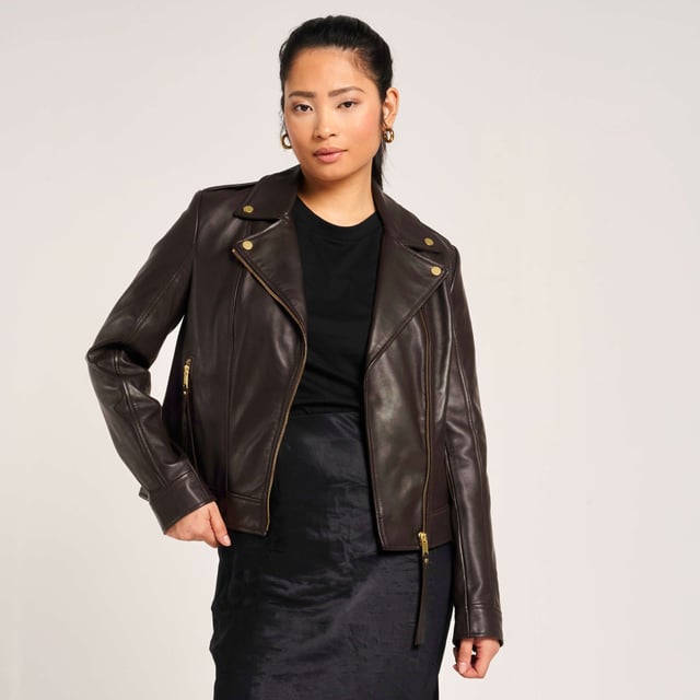 Barneys Originals real leather asymmetric biker jacket in a rich chocolate brown, featuring gold trims that beautifully complement the color. Crafted from soft, luxurious leather for a timeless and elegant finish.