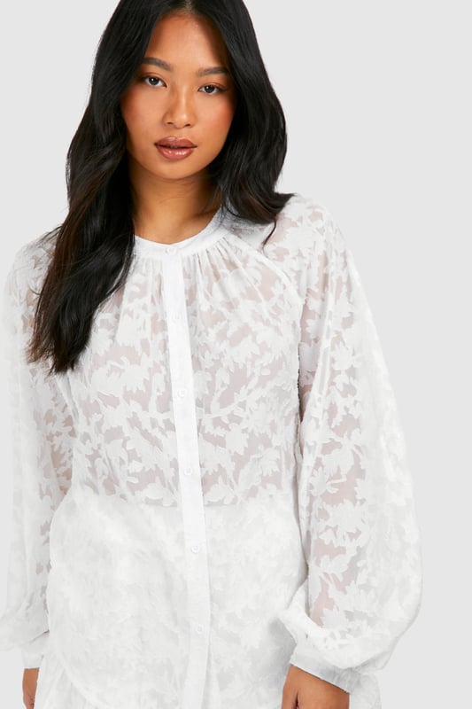 Sheer, textured fabric for a breezy beach look
        Voluminous balloon sleeves add drama
        Button-down front for versatile styling
        Gathered neckline creates a feminine silhouette
        Matching shorts for a coordinated set
    
    Make a statement on your next beach getaway with this eye-catching petite beach shirt. The sheer, textured fabric offers a tantalising glimpse of skin while keeping you cool in the sun. The voluminous balloon sleeves add a touch of drama, perfect for those sunset strolls along the shore. Wear it buttoned up as a chic cover-up over your swimwear, or leave it open for a more relaxed vibe. The gathered neckline creates a flattering, feminine silhouette that's sure to turn heads. Pair it with the matching shorts for a coordinated look that takes you effortlessly from beach to bar. This versatile piece is a must-have for any summer wardrobe, whether you're lounging by the pool or sipping cocktails at a beachside caf.