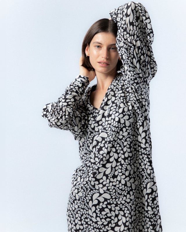 El vestido corto Paula en blanco y negro es sinónimo de elegancia, con este vestido de manga abullonada elevarás tu estilo invernal. Además, su pañuelo a juego te permitirá crear distintos looks con este vestido blanco y negro.
 
 
 
 Vestido corto con cuello pico.
 
 Manga larga acabada con puño con cremallera.
 
 Cierre lateral con cremallera oculta en costura.
 
 Con pañuelo confeccionado en mismo tejido y cara interna con tejido color negro.
 
 Tejido estampado blanco y negro con detalles de foil dorado.