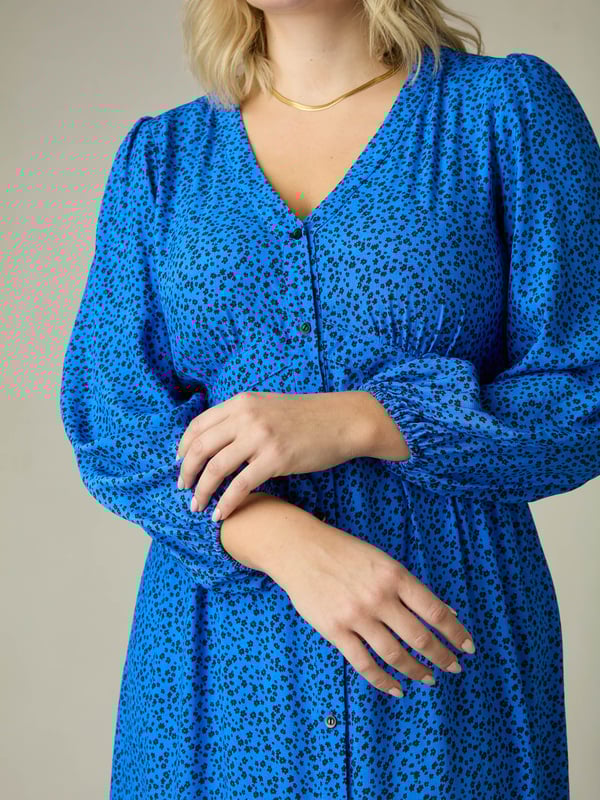 Printed all over with a beautiful blue ditsy print, this dress is cut from a soft woven fabric that moves beautifully. With a flattering tiered shape, it has a button-through front and an elasticated waistband to ensure the perfect fit. Voluminous sleeves add to its elegant silhouette, making it the perfect dress to elevate your everyday.