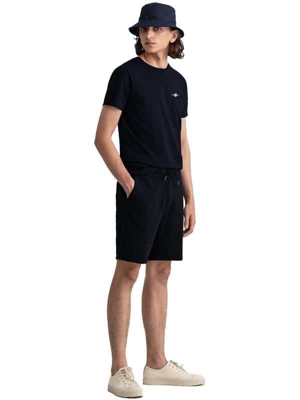 Gant introduces a mens t-shirt and shorts set with a small-scale embroidered shield graphic on the chest. Made of soft cotton and featuring a ribbed neckline, this tee showcases the iconic GANT logo. Crafted for everyday wear, the regular-fit tee is both comfortable and sustainable with Better Cotton. The included sweat shorts, also made of soft cotton blend, feature a ribbed waistband, three pockets, and a drawstring waist. The shorts are adorned with a small-scale embroidered shield graphic.