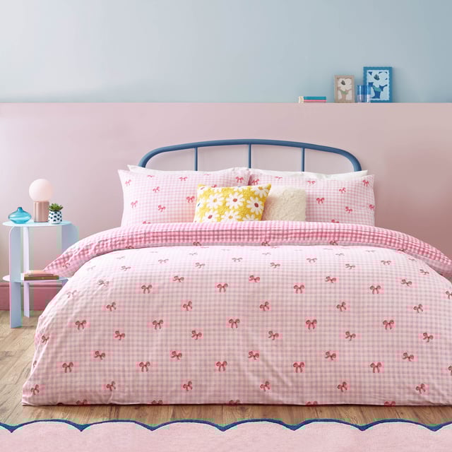 Brighten up your bedroom with the Gingham Bows Checked Duvet Cover Set, a perfect blend of classic charm and contemporary playfulness. Featuring a timeless gingham pattern adorned with delicate bows, this set adds a subtle yet striking detail to your space. The reversible design, with a small-scale check on the reverse side, offers effortless versatility, giving you two stylish looks in one. Crafted from a durable polycotton blend, it promises a soft touch, easy care, and a relaxed finish. Elevate your home with a piece that combines trending design with timeless charm, perfect for creating a cosy yet refined retreat.
