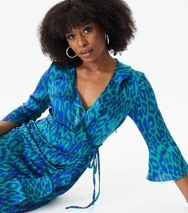 "Da rienda suelta a tu lado salvaje con nuestro vestido cruzado con volantes y estampado animal verde. Este vestido llamativo presenta un estampado animal llamativo y detalles de volantes favorecedores que elevarán tu juego de moda. El estilo cruzado favorece tu figura, lo que lo convierte en una prenda versátil y elegante. elección para cualquier ocasión.