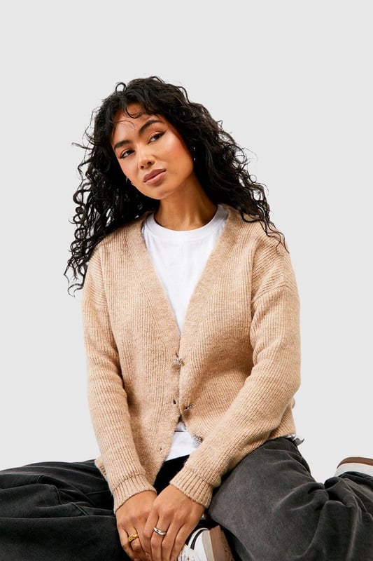 Soft knit texture for ultimate comfort
        Slouchy, relaxed fit for effortless style
        Eye-catching rhinestone buttons add a touch of glamour
        Versatile open-front design for easy layering
        Ribbed cuffs and hem for a polished finish
    
    Embrace laid-back luxury with this slouchy cardigan, perfect for the fashion-forward woman who values both style and comfort. The soft knit fabric drapes beautifully, creating a relaxed silhouette that's ideal for casual outings or cosy nights in. The standout feature is undoubtedly the sparkling rhinestone buttons, which add a subtle touch of glamour to this otherwise understated piece. Style it over a simple white tee and wide-leg trousers for a chic daytime look, or throw it on over a slip dress for an evening ensemble with a twist. For a trendy finish, pair with a beanie and chunky trainers as seen on our model. This cardigan is a versatile staple that will quickly become your go-to for family gatherings, coffee dates, or lazy weekends at home.