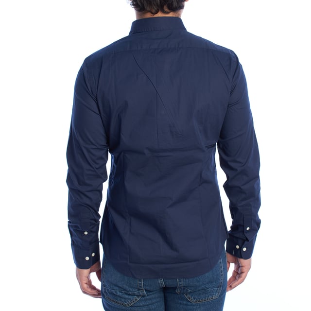 Camisa clásica de hombre La Martina. 

Una prenda imprescindible en el armario masculino que equilibra a la perfección estilo y funcionalidad. Esta camisa de La Martina destaca por su diseño atemporal y detalles sofisticados que reflejan la esencia de la marca.

Detalles:

- Camisa de manga larga con cierre frontal de botones.
- Diseño de corte ajustado que se adapta perfectamente al cuerpo.
- Confeccionada en algodón de alta calidad, ligero y transpirable.
- Logotipo de La Martina bordado en el pecho.
- Puños ajustables con doble botón para un mejor ajuste.
- Cuello clásico que se adapta a cualquier look.
- Dobladillo curvado que facilita su uso por dentro o fuera del pantalón.
- Etiqueta decorativa en la parte inferior que refuerza la autenticidad de la marca.
- Corte recto que asegura un calce cómodo y estilizado.

Una camisa manga larga versátil que combina elegancia y comodidad, ideal para ocasiones formales o para elevar un look casual. Perfecta para quienes valoran la calidad y los detalles de diseño exclusivos.
 Composición: 97% Algodón, 3% Poliéster
 Cuidados:
- Lavar máximo a 30°C en ciclo delicado.
- No usar lejía ni blanqueadores.
- Planchar a baja temperatura, preferiblemente del revés.
- No usar secadora.