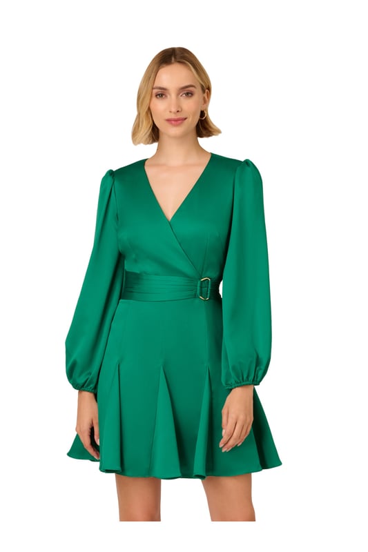 Short length mermaid dress made out of a solid satin fabric with surplice neckline, long sleeves, shirred self-tie belt and gold ring detail on the waist, inserted godet skirt, and zipper at the centre back.
