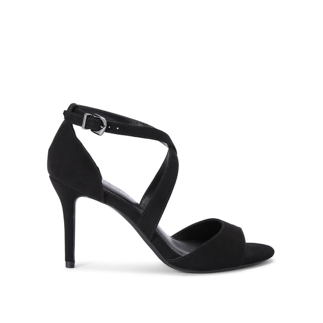 The Carvela black Kross Sandal features a microsuede upper with open toe and crossed straps across the foot. The ankle is fastened with metal faceted buckle. Heel height: 90mm.