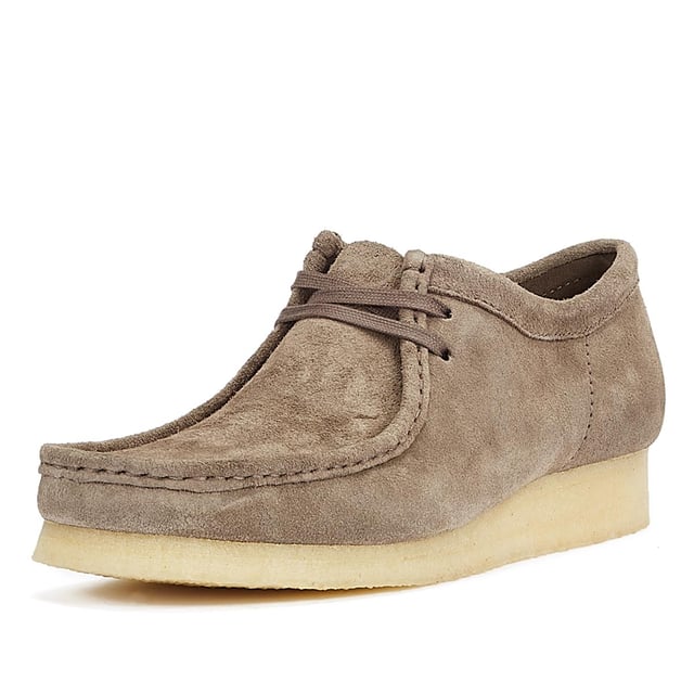 These shoes feature suede uppers, flat laces, and tonal fobs, marking Clarks' commitment to quality. They are complete with natural crepe soles, ensuring both style and comfort.