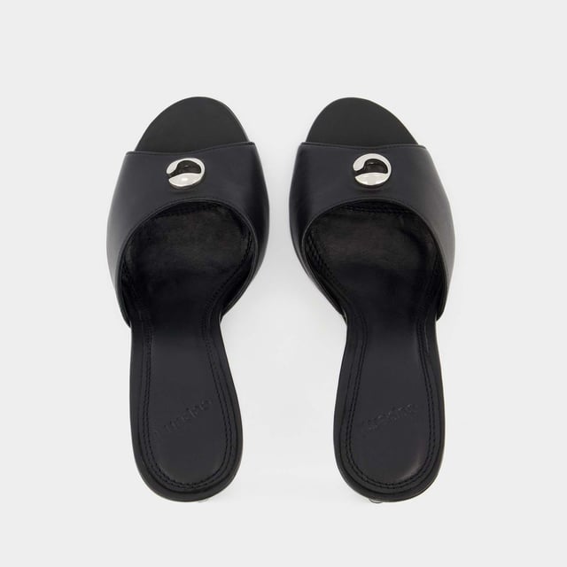 Ponte estos mules negros Coperni para cualquier ocasión. Atemporales, con su logo plateado, combinarán con todos tus looks. Altura del tacón: 6 cm. Colores: Negro. Material principal: piel de ternero lisa. Material de la suela: sintético. Material del forro: cuero. Cierre: fácil de poner. Forma de la puntera: redonda abierta. Ajuste: fiel a la talla - Tallaje: europeo.