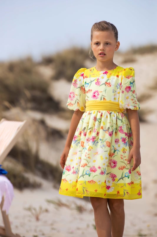 Presenting the Girls Floral Party Dress in Yellow by Patachou, a striking addition to any Girls' wardrobe. Perfect for Easter and beyond, its key attributes include: Stylish Design: The charming floral print adorns this dress, instilling a contemporary yet playful edge, marking it as a standout ensemble. Optimum Comfort: Crafted from superior materials, this dress ensures lasting comfort while your child embarks on daily explorations.  Wardrobe Upgrade: Elevate your Girls' wardrobe with this stunning yellow dress from Patachou. Purchase today for an instant style uplift!