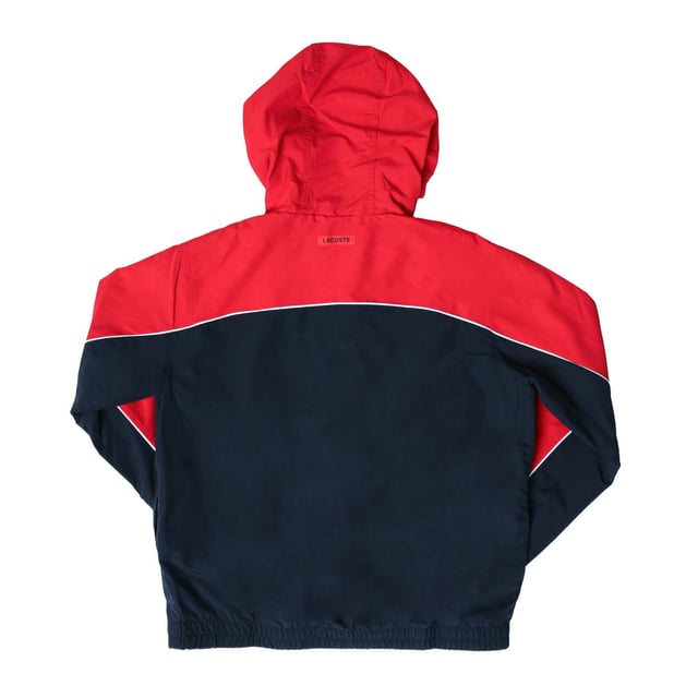 Junior Lacoste Water- Repellent Windbreaker Jacket in red navy.- Hood with adjusting system at back and front.- Half zip fastening.- Mesh lining.- Elasticated cuffs and hem.- 100% Polyester.- Ref: BJ9809528