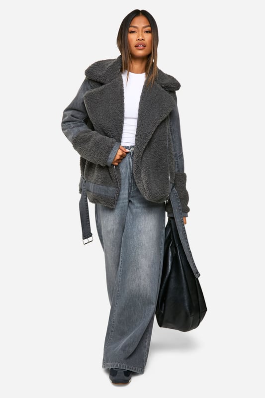 Cosy teddy fabric body with contrasting denim sleeves
        Oversized notched lapel collar for added warmth
        Asymmetric zip front closure for a modern twist
        Wide belt with metal buckle to cinch the waist
        Relaxed fit perfect for layering over chunky knits
    
    Make a bold statement this season with our eye-catching Teddy-Fliegerjacke. This unique hybrid design combines the warmth of a teddy coat with the edgy appeal of a denim jacket. The plush teddy fabric body keeps you snug, while the rigid denim sleeves add a cool, contrasting texture. Style it with wide-leg jeans and trainers for a casual weekend look, or throw it over a midi dress and ankle boots for a night out with the girls. The versatile nature of this jacket makes it perfect for various casual occasions, from coffee dates to family gatherings. The oversized collar and waist-cinching belt allow you to customise your look, making this piece a true wardrobe staple that you'll reach for time and time again.
