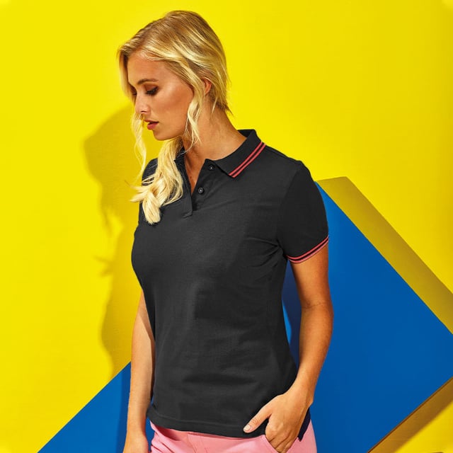 Fitted polo for women with tipped contrast detail to the collar and cuffs. Features two contrast coloured buttons on placket and a contrast colour on side vents. Also includes twin-needle stitching on hem and a ribbed knit collar and sleeve cuffs. Sizes: XS (8 UK), S (10 UK), M (12 UK), L (14 UK), XL (16 UK), XXL (18 UK). Materials: 100% ringspun combed cotton, Other materials: (Charcoal) 60% cotton, 40% polyester, (Heather Grey) 85% cotton, 15% viscose.