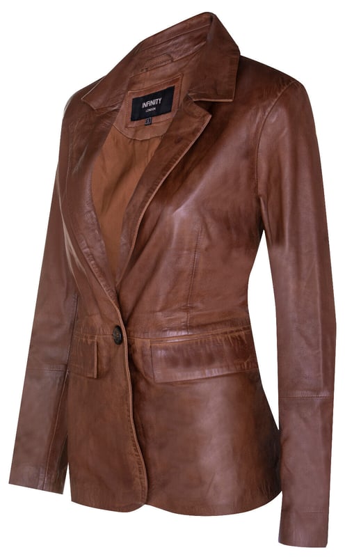 Elevate your style with our Women's Leather Blazer Jacket, a perfect blend of luxury and versatility. Crafted from soft and supple lambs nappa leather, this jacket offers a luxurious and comfortable feel. Here's what sets it apart:  
Luxurious Lambs Nappa Leather: The soft and supple lambs nappa leather construction ensures both style and comfort, making it a delightful addition to your wardrobe. 
Functional Waist Pockets: Two exterior waist pockets add a touch of functionality and style, allowing you to carry your essentials with ease. 
Versatile Color Options: Available in two stunning colors, this jacket provides the freedom to express your personal taste and style. 
Sophisticated Collar: The collar showcases notched lapels, adding a sophisticated touch and a classic look to the overall design. 
Elegant One-Button Closure: With a one-button closure, this blazer-style jacket exudes elegance and versatility, making it suitable for various occasions, whether you're heading to the office or going out for a night on the town.  The Women's Leather Blazer Jacket is the perfect choice for those who seek both luxury and style in their attire.