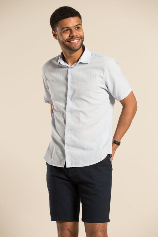 This classic linen blend, short-sleeve shirt from Nines is a must-have for any wardrobe.  Made from a breathable blend of linen and cotton, this shirt offers both comfort and style with its classic fit. This shirt features a button-down fastening, turn-up cuffs, and subtle embroidered brand detail on the chest. Other colours available.