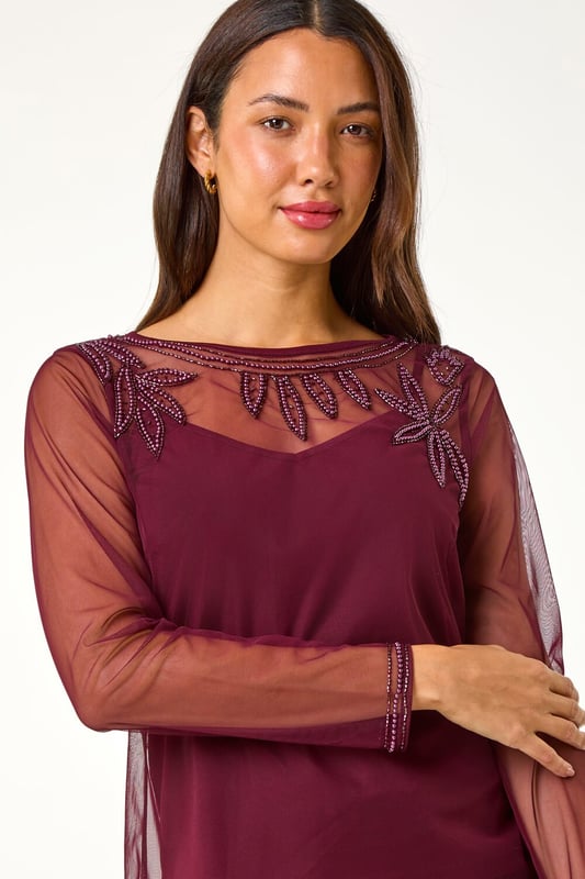 Embellished Sequin Mesh Top from Roman. Add some sparkle to your Autumn/Winter wardrobe with this dazzling sequin mesh top. Featuring long sleeves, a stylish slash neckline, this top is perfect for a night out. The sequin trim on the yoke and sleeves adds a touch of glamour to your ensemble. Pair with pleather trousers and heeled boots for a party ready look that will have you turning heads all night long!