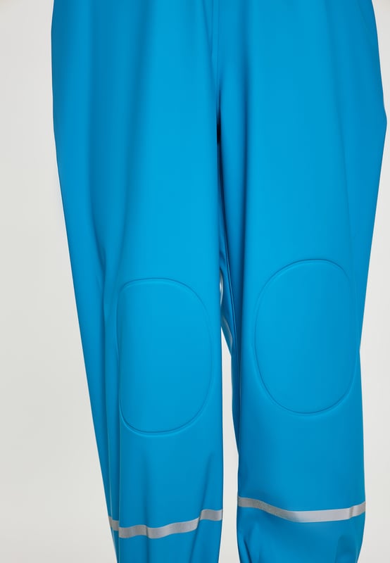 Maak kennis met een waterdichte tuinbroek voor kinderen met versterkte knieën en zitvlak voor duurzaamheid. Verstelbare bandjes met gespen zorgen voor een persoonlijke pasvorm, en de elastische taille en beenuiteinden zorgen voor comfort en flexibiliteit. Met reflecterende strips die zichtbaarheid garanderen en gelaste naden is dit pak perfect om buiten te spelen en te verkennen. Broek gemaakt van 3000 mm waterdicht materiaal. Dit product maakt deel uit van de Kidscollectie.  Regenbroek